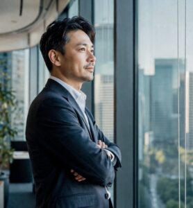 社長がオフィスの外を眺め事業を思案中